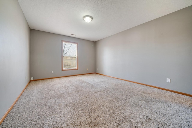 spare room with visible vents, baseboards, carpet floors, and a textured ceiling