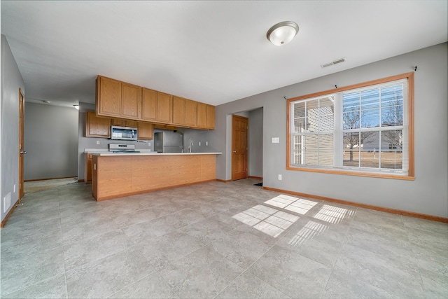 kitchen featuring visible vents, baseboards, appliances with stainless steel finishes, and light countertops