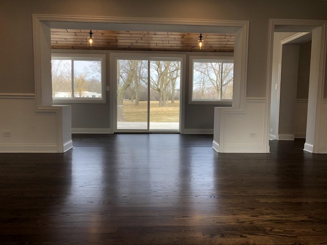 interior space featuring baseboards and dark wood finished floors