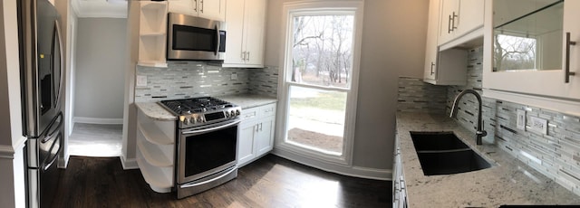 kitchen with dark wood finished floors, white cabinetry, appliances with stainless steel finishes, and a sink