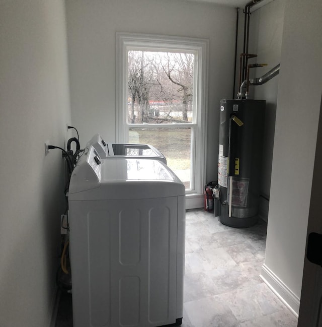 washroom with gas water heater, separate washer and dryer, baseboards, and laundry area