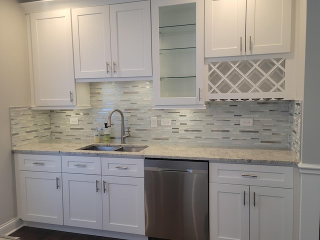 kitchen featuring a sink, decorative backsplash, dishwasher, and white cabinetry