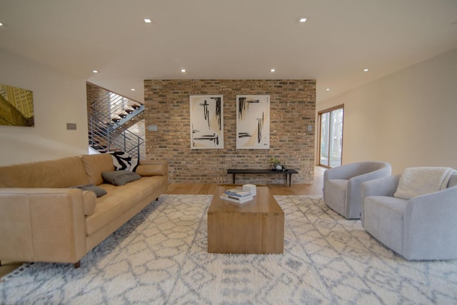 living room featuring recessed lighting, stairs, wood finished floors, and brick wall