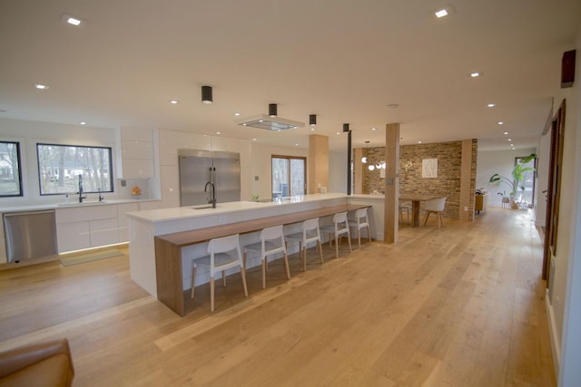 kitchen featuring a sink, stainless steel appliances, modern cabinets, and white cabinets