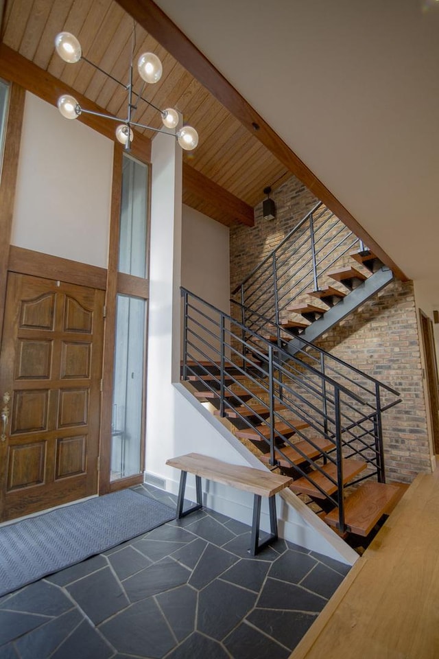 entryway featuring beamed ceiling, wooden ceiling, stairway, and a towering ceiling