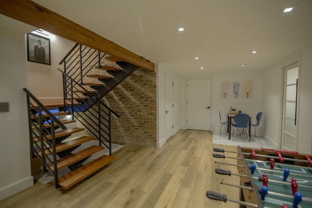 interior space featuring recessed lighting, brick wall, baseboards, and wood finished floors