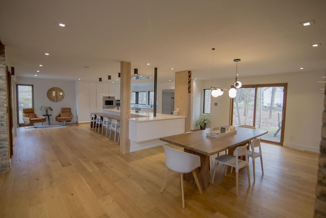 dining room with recessed lighting, light wood-type flooring, and baseboards