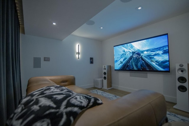 home theater room with light wood-style flooring and baseboards