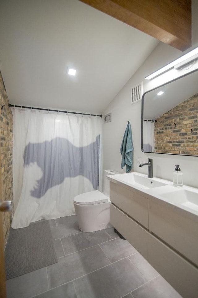 bathroom featuring visible vents, toilet, vaulted ceiling, tile patterned floors, and vanity