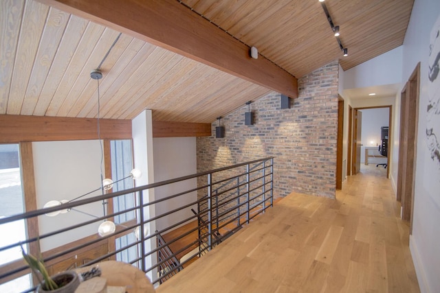 corridor with track lighting, brick wall, vaulted ceiling with beams, wooden ceiling, and wood finished floors