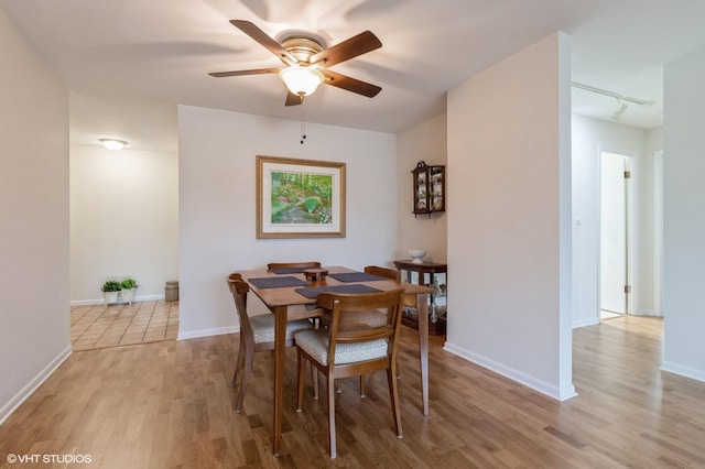 dining area with light wood-type flooring, baseboards, ceiling fan, and track lighting