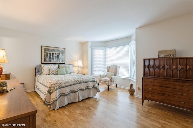 bedroom with light wood finished floors and baseboards