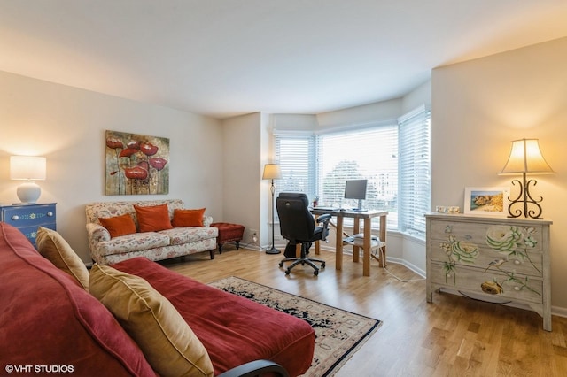 home office with light wood-style flooring and baseboards