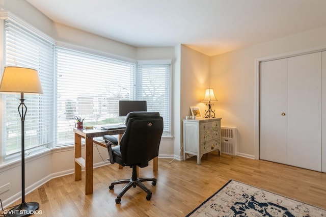 office area featuring light wood-type flooring and baseboards