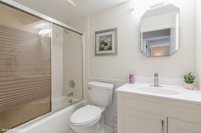 bathroom with vanity, enclosed tub / shower combo, tile walls, toilet, and tile patterned floors