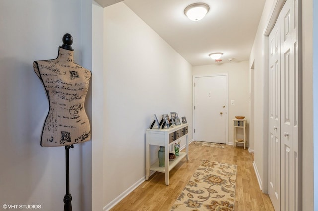 hallway featuring light wood-type flooring and baseboards