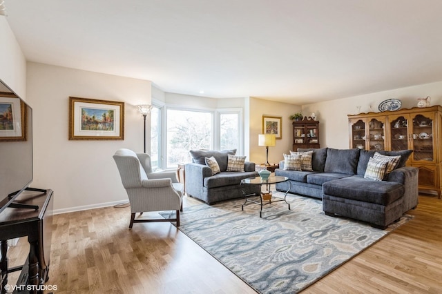 living room with baseboards and light wood finished floors
