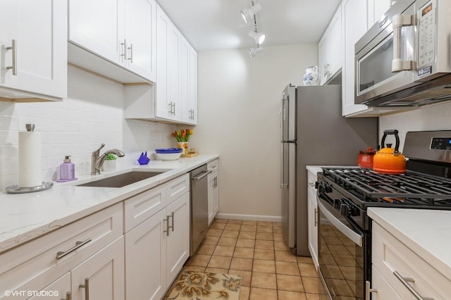 kitchen featuring backsplash, white cabinetry, stainless steel appliances, and a sink