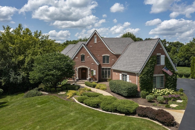 view of front of home with a front lawn and brick siding