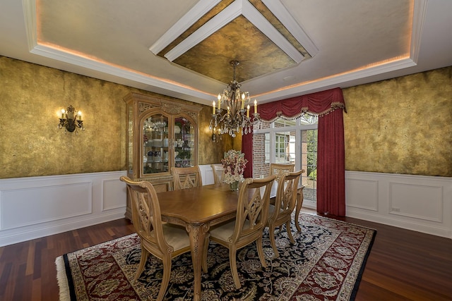 dining room with an inviting chandelier, a tray ceiling, dark wood-style flooring, and wainscoting