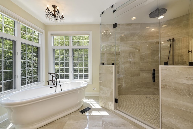 bathroom featuring baseboards, a freestanding tub, a shower stall, a notable chandelier, and marble finish floor