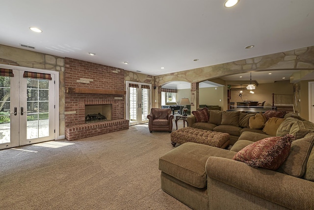 living area featuring visible vents, carpet floors, recessed lighting, arched walkways, and french doors