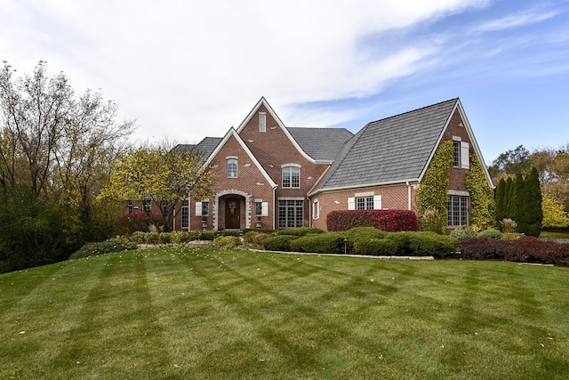 view of front of property with brick siding and a front lawn