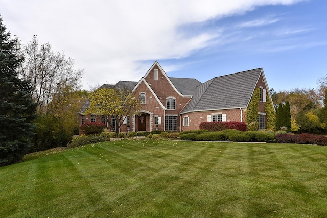 view of front of property featuring brick siding and a front yard