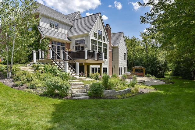 back of house featuring a patio, stairs, a yard, a wooden deck, and a chimney