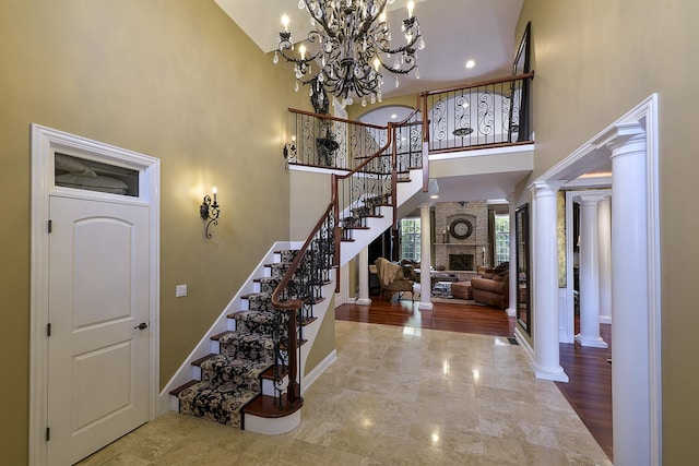 entryway with stairs, a high ceiling, a notable chandelier, and baseboards