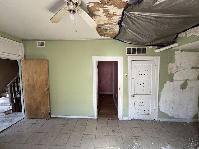 interior space featuring visible vents, baseboards, and a ceiling fan