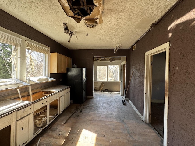 kitchen featuring a textured ceiling and freestanding refrigerator