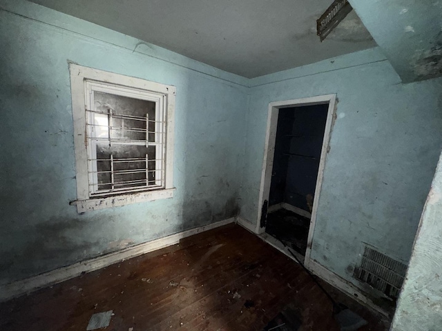 empty room featuring hardwood / wood-style floors and visible vents