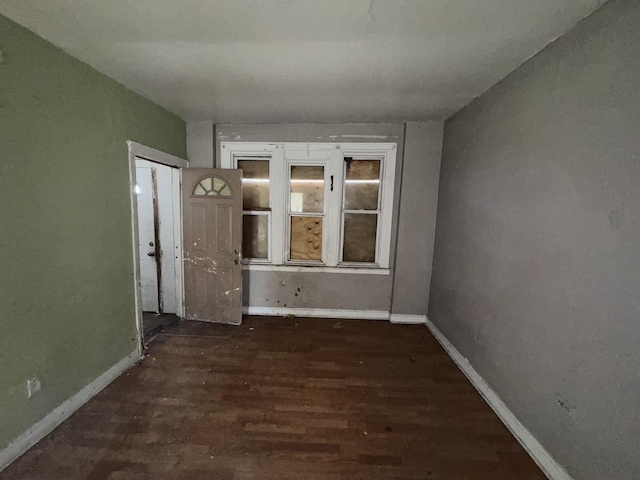 unfurnished room with baseboards and wood finished floors