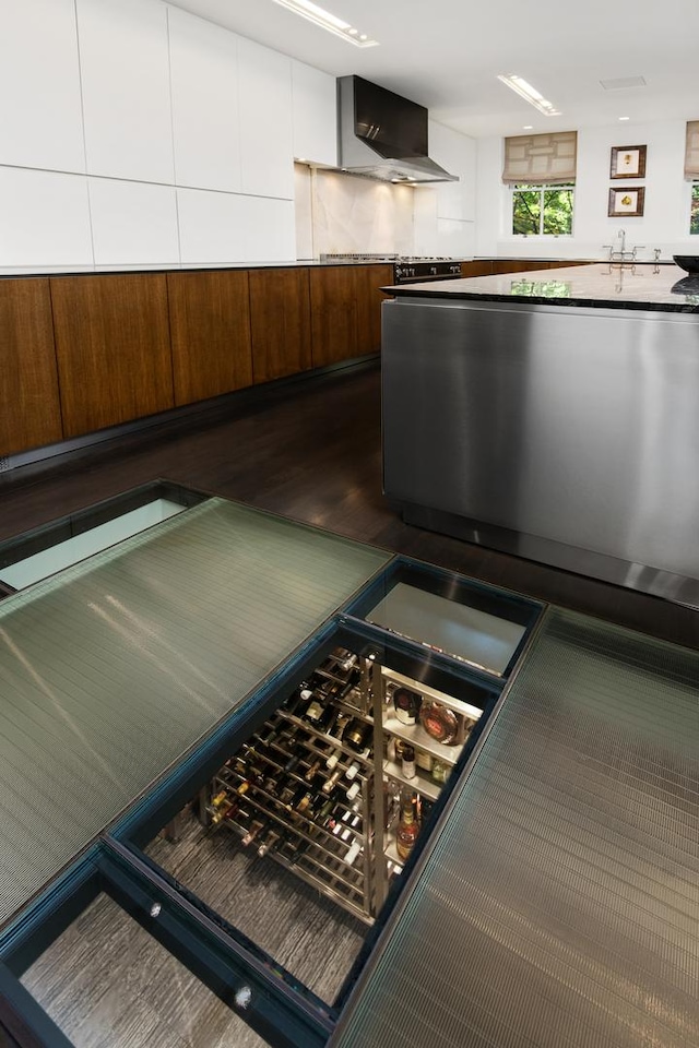 kitchen with dark wood-style floors and wall chimney exhaust hood