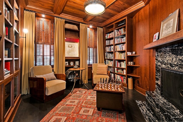 living area with built in shelves, crown molding, beam ceiling, wooden ceiling, and wood finished floors