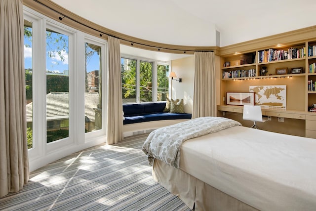 bedroom with access to exterior, built in study area, and lofted ceiling