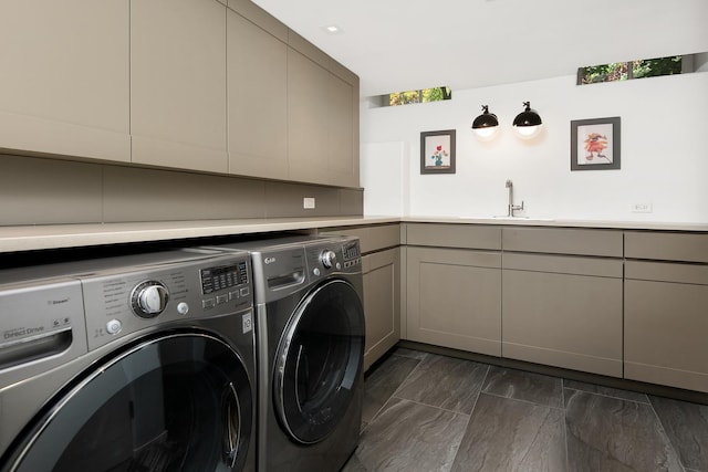 washroom with cabinet space, washer and dryer, wet bar, and a sink