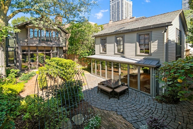 rear view of house featuring a patio area and a chimney