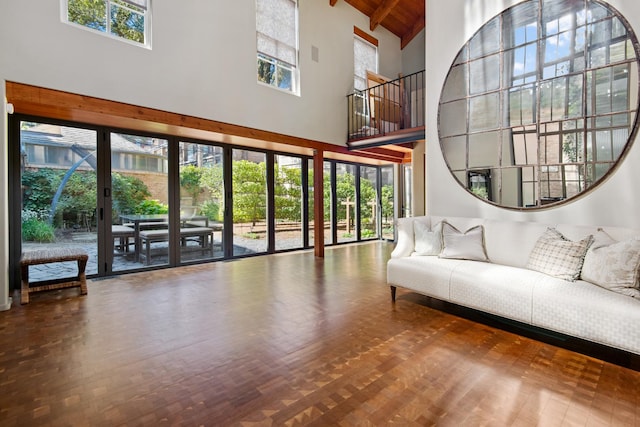 living area with beam ceiling, wooden ceiling, high vaulted ceiling, and wood finished floors