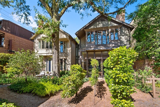 rear view of property featuring a balcony and a sunroom