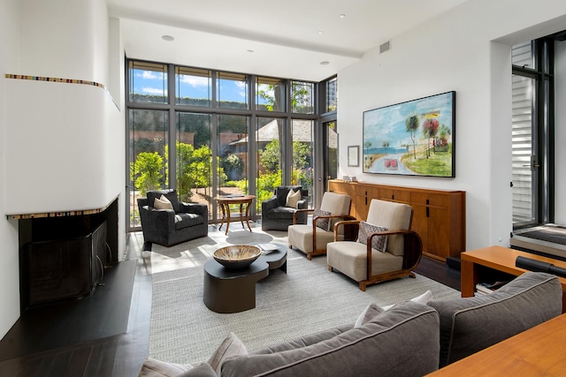 living area featuring a wall of windows, wood finished floors, and visible vents