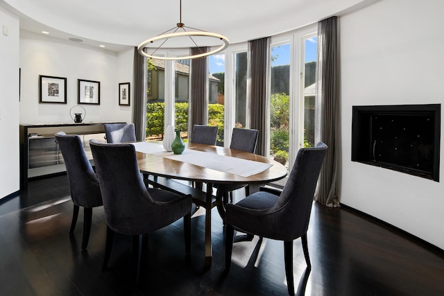 dining space with dark wood-type flooring, recessed lighting, a wealth of natural light, and a chandelier