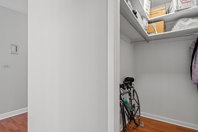 walk in closet with wood finished floors