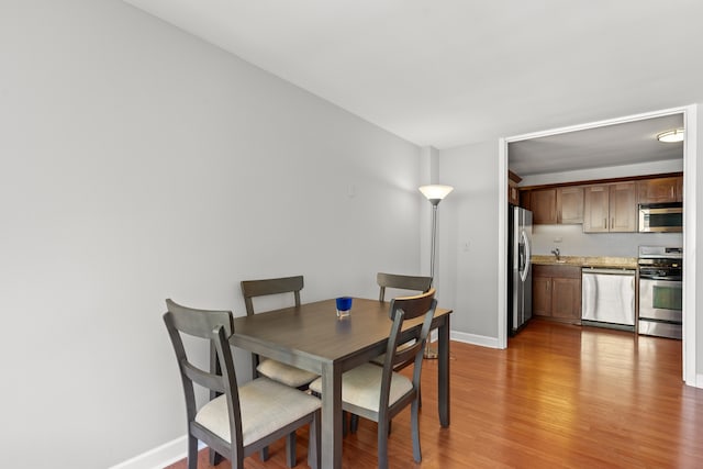 dining room featuring baseboards and light wood-style floors