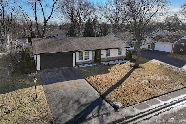 single story home featuring brick siding, concrete driveway, a garage, and fence