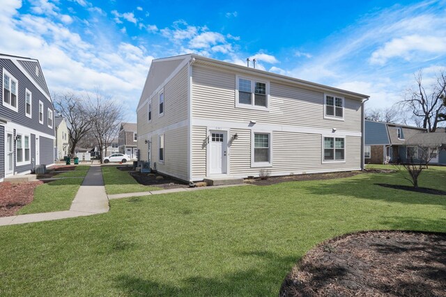 rear view of property featuring a lawn
