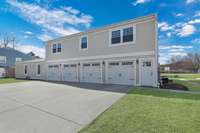 view of front of home featuring cooling unit, driveway, an attached garage, and a front lawn