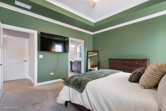 carpeted bedroom featuring visible vents, baseboards, and ensuite bath