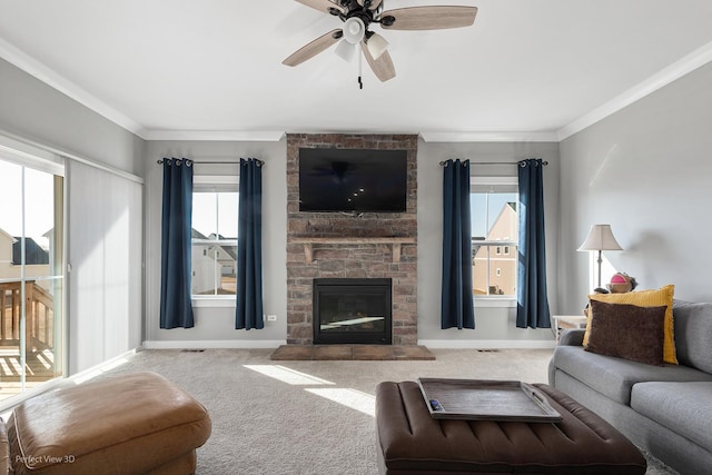 carpeted living area with a fireplace, baseboards, crown molding, and ceiling fan